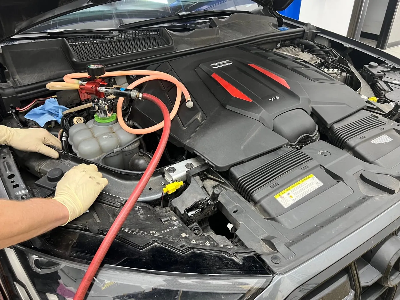 Technician servicing the cooling system on an Audi V6