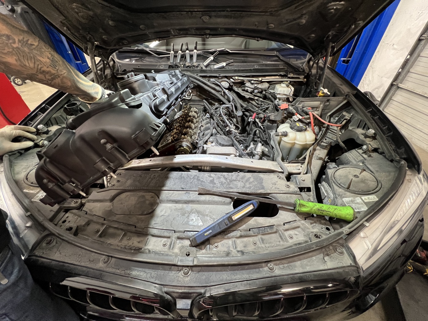 BMW intake manifold removed with tools laid out for detailed engine work