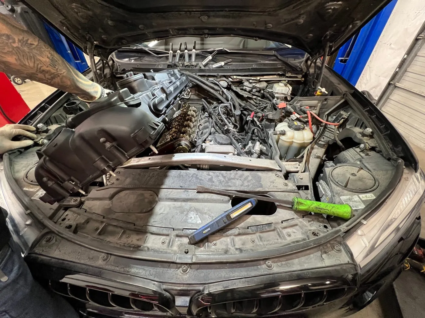 BMW intake manifold removed for carbon cleaning with tools laid out